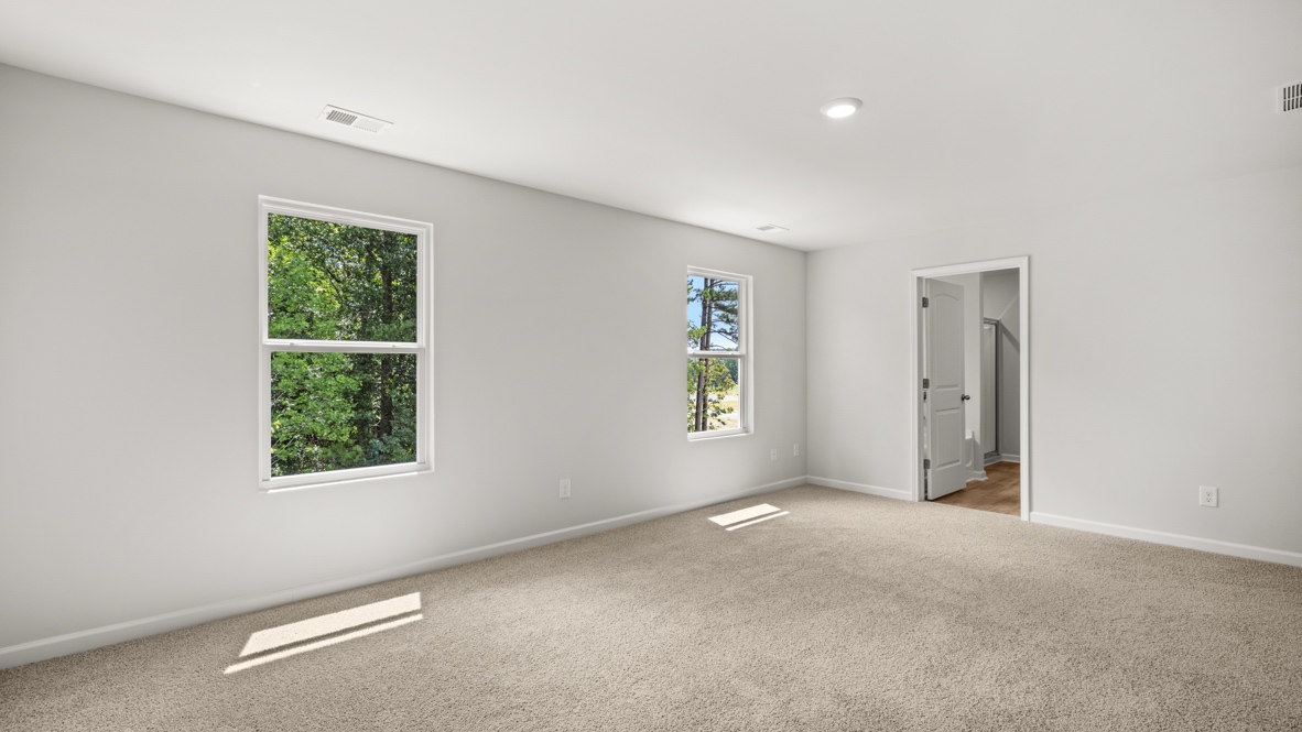 bedroom with beige carpet, grey walls and a window
