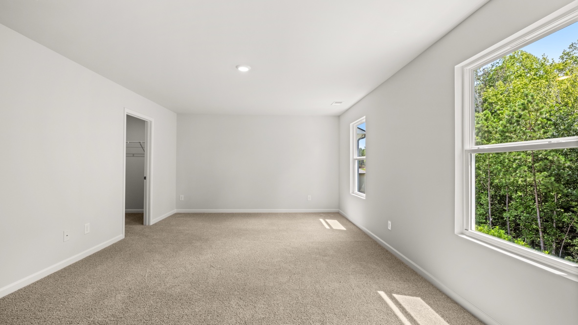 bedroom with beige carpet, grey walls and a window