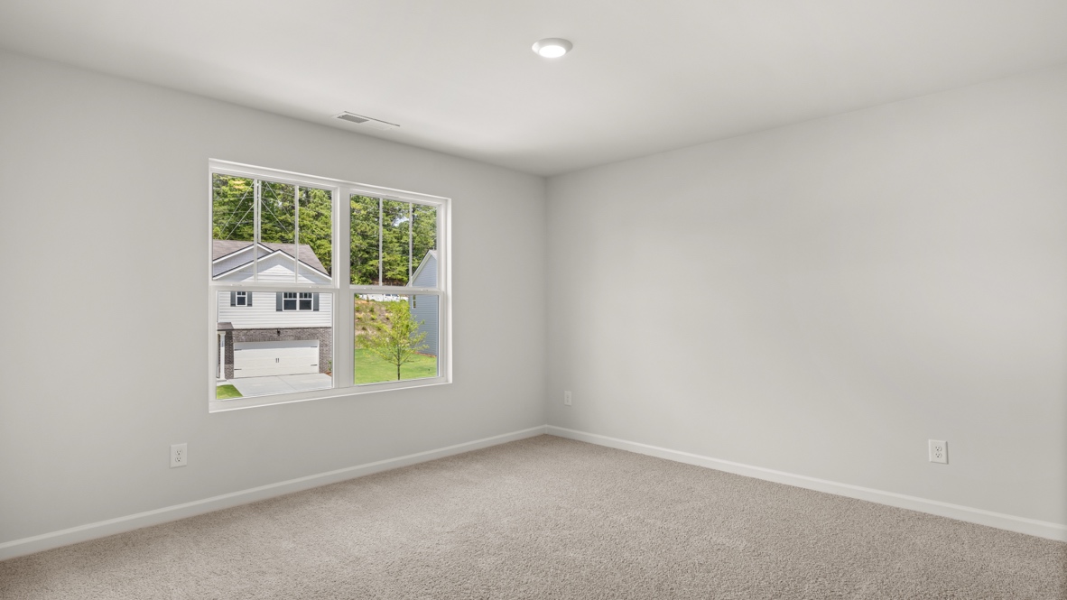 bedroom with beige carpet, grey walls and a window