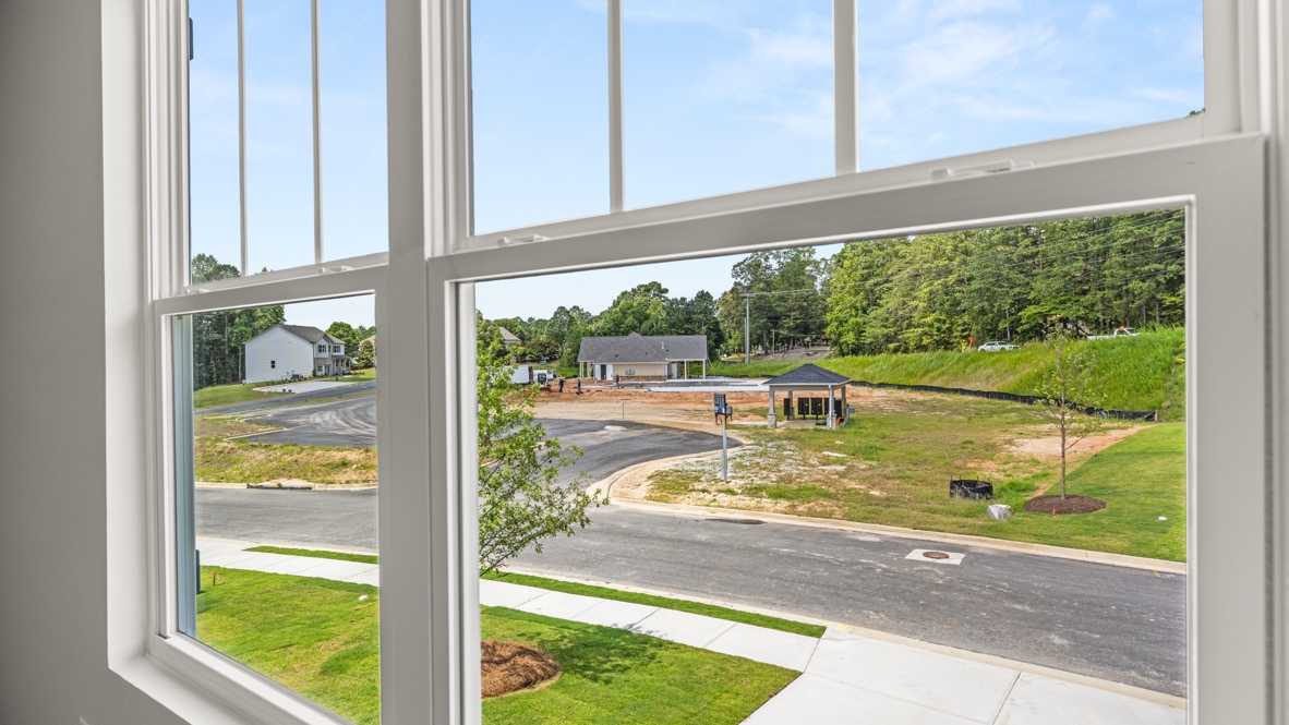 bedroom with beige carpet, grey walls and a window