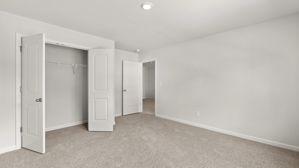 bedroom with beige carpet, grey walls and a window