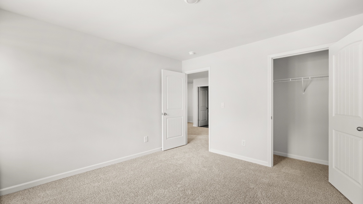 bedroom with beige carpet, grey walls and a window