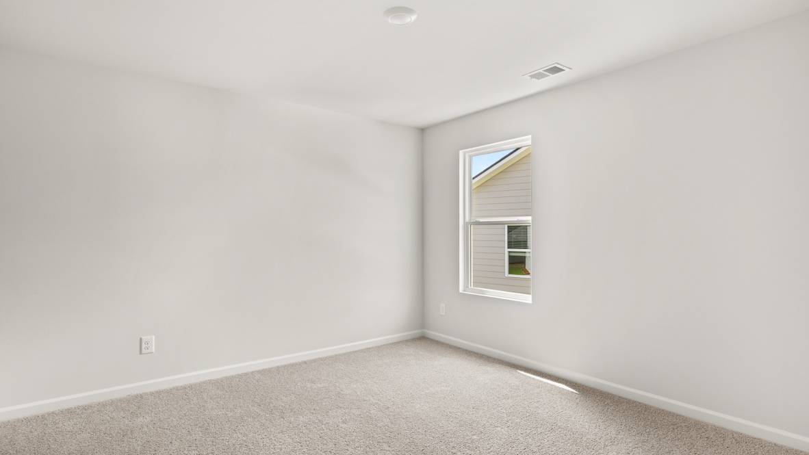 bedroom with beige carpet, grey walls and a window