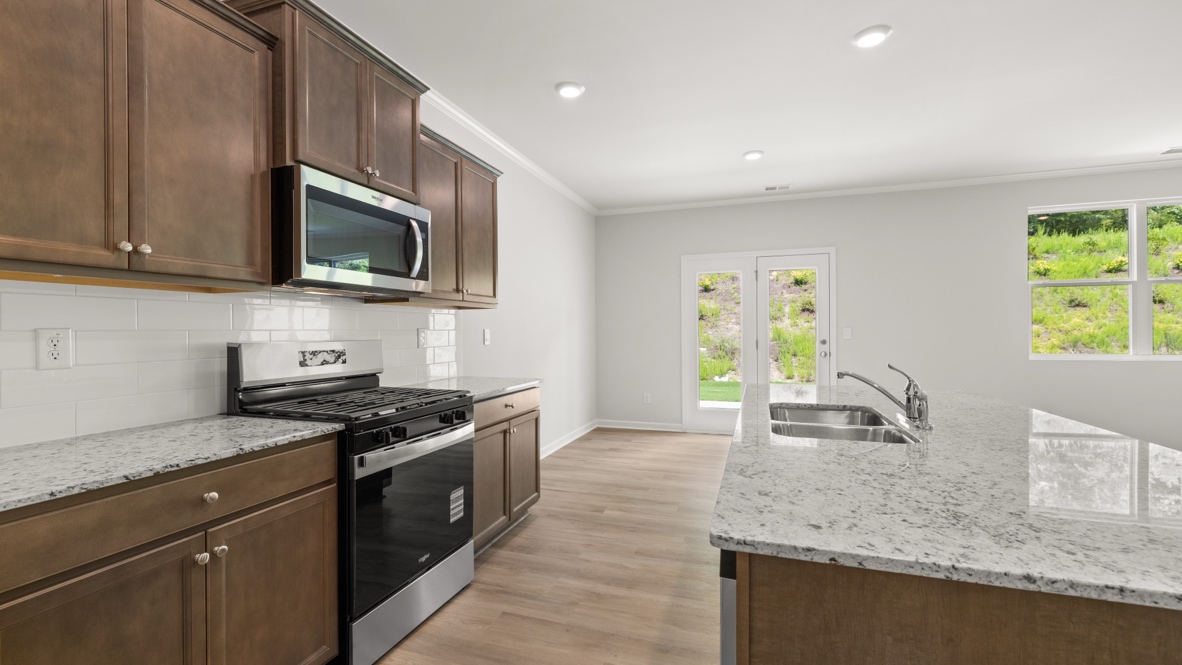 kitchen with brown cabinetry, large island and stainless steel appliances