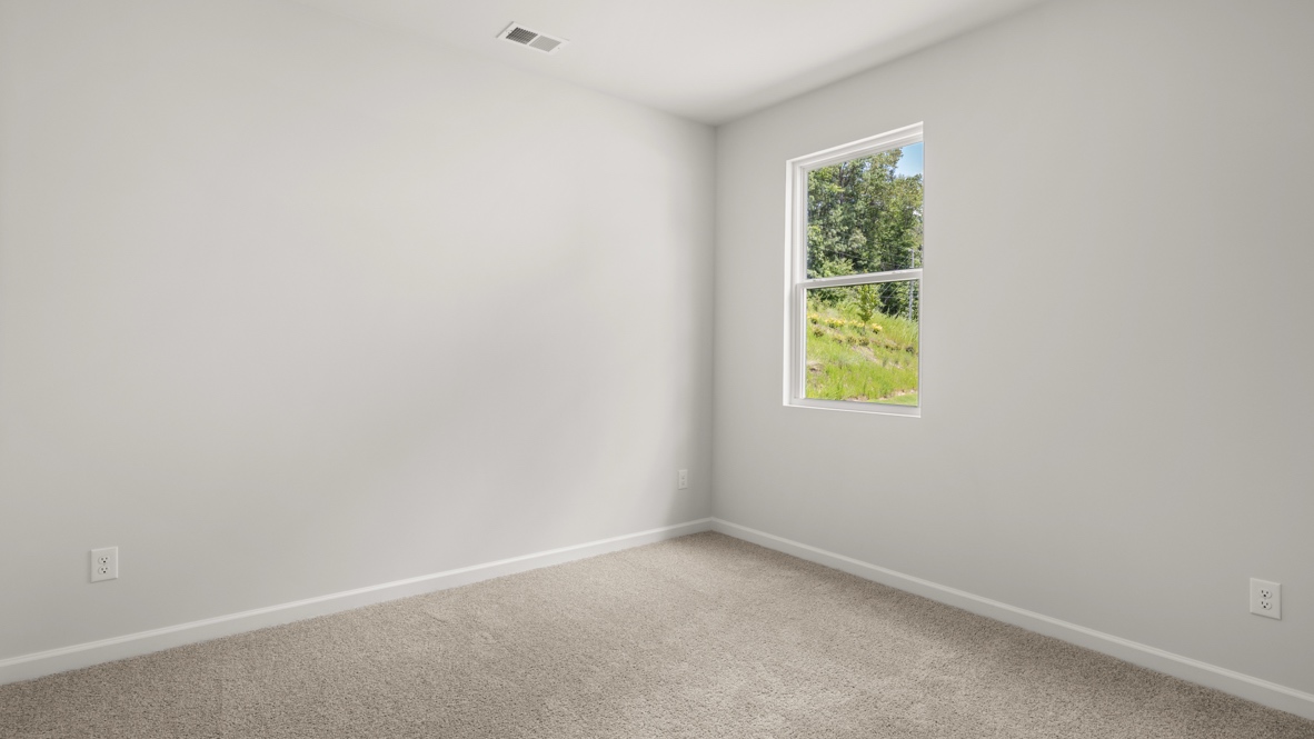 bedroom with beige carpet, grey walls and a window