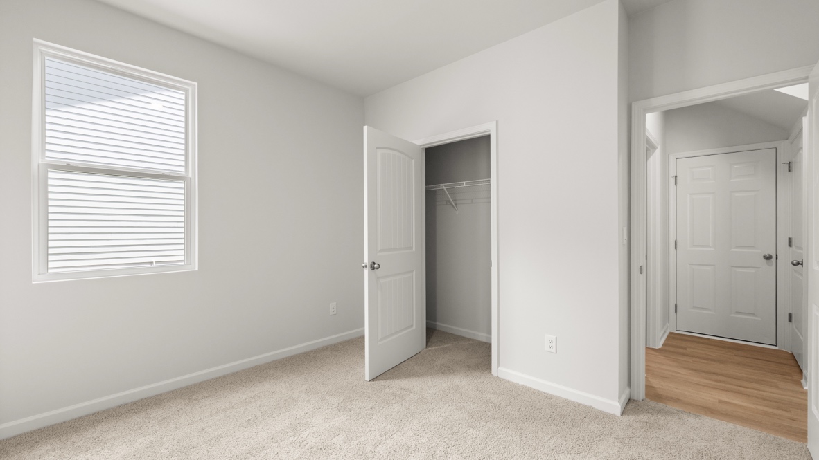 bedroom with beige carpet, grey walls and a window