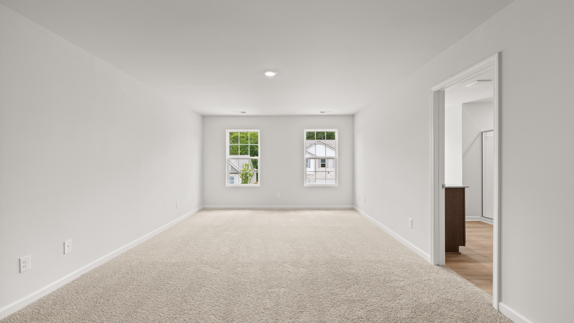 bedroom with beige carpet, grey walls and a window