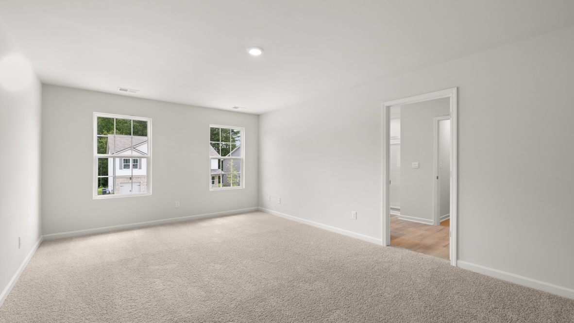 bedroom with beige carpet, grey walls and a window