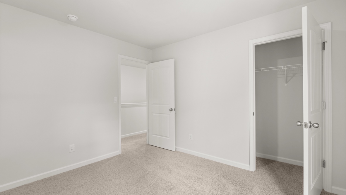 bedroom with beige carpet, grey walls and a window