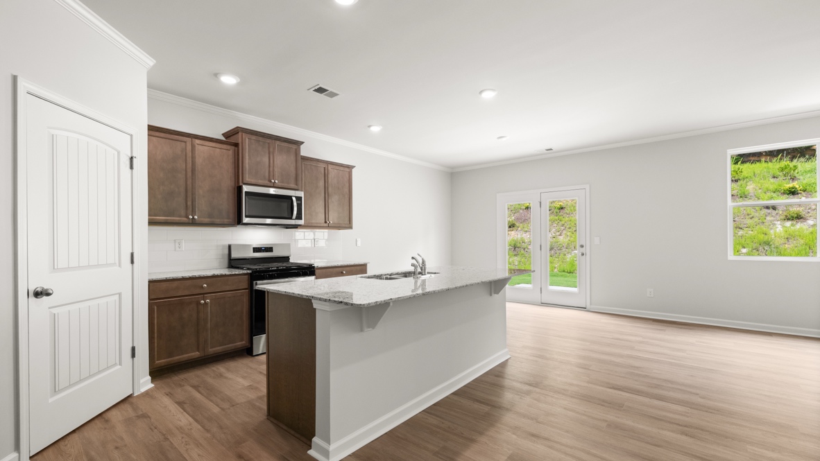 kitchen with brown cabinetry, large island and stainless steel appliances