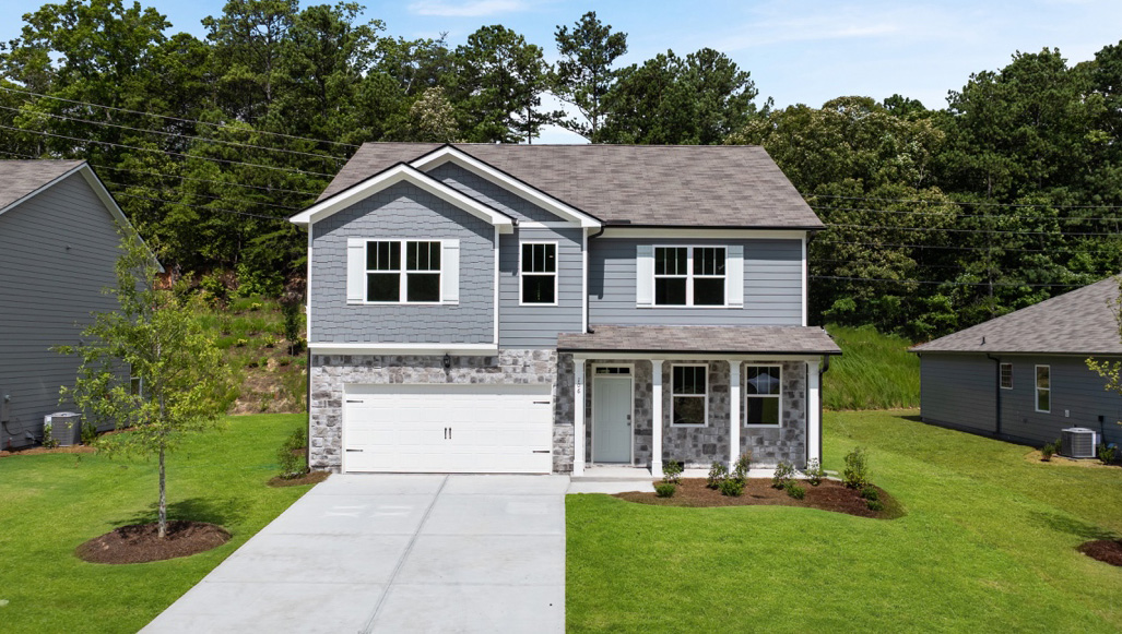 Front exterior of a two story model home featuring white siding and pink brick accents
