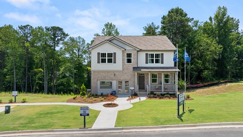 Front exterior of a two story model home featuring white siding and pink brick accents