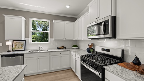 kitchen with white cabinetry, large island, and stainless steel appliances