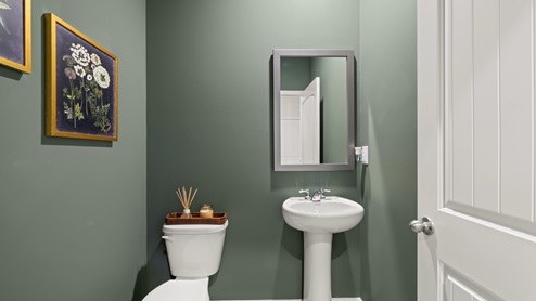 Powder bathroom with a pedestal sink and mirror