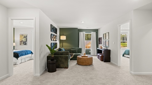 flex area with beige carpet, white walls and a window