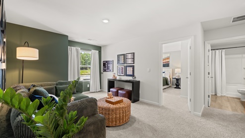 flex area with beige carpet, white walls and a window