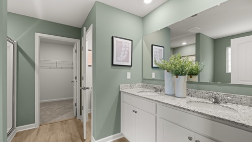 bathroom with dual vanity sinks, toilet, and a walk in shower