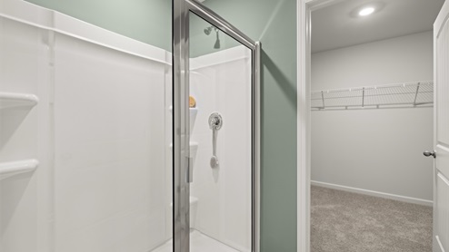 bathroom with dual vanity sinks, toilet, and a walk in shower
