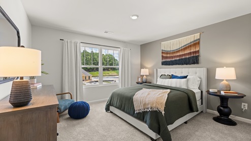 bedroom with beige carpet, grey walls and a window