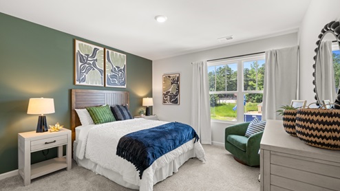 bedroom with beige carpet, white walls and a window