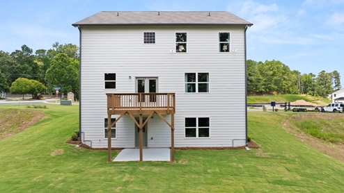 rear exterior of home featuring a spacious backyard