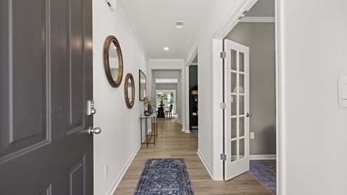 front entry way of home featuring brown flooring and white walls