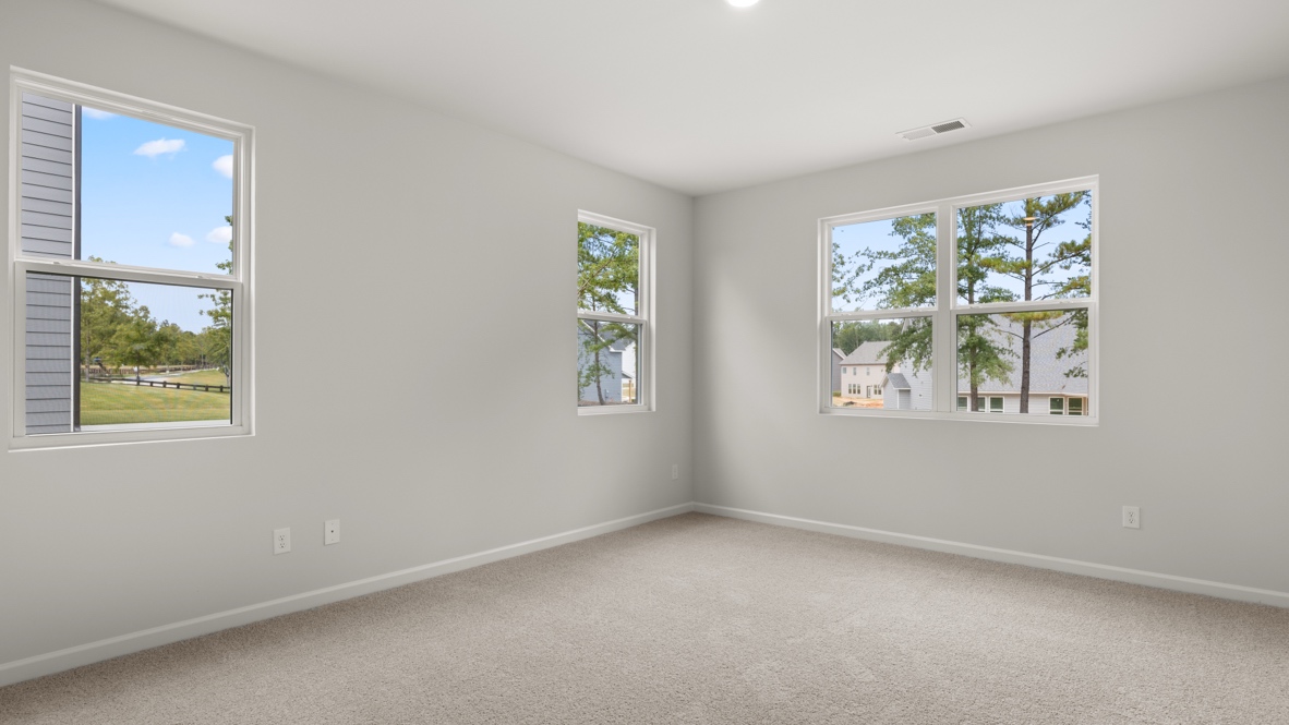 Interior primary bedroom with large windows