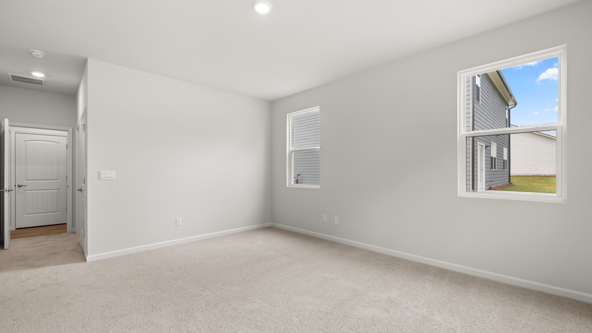 Interior primary bedroom with large windows