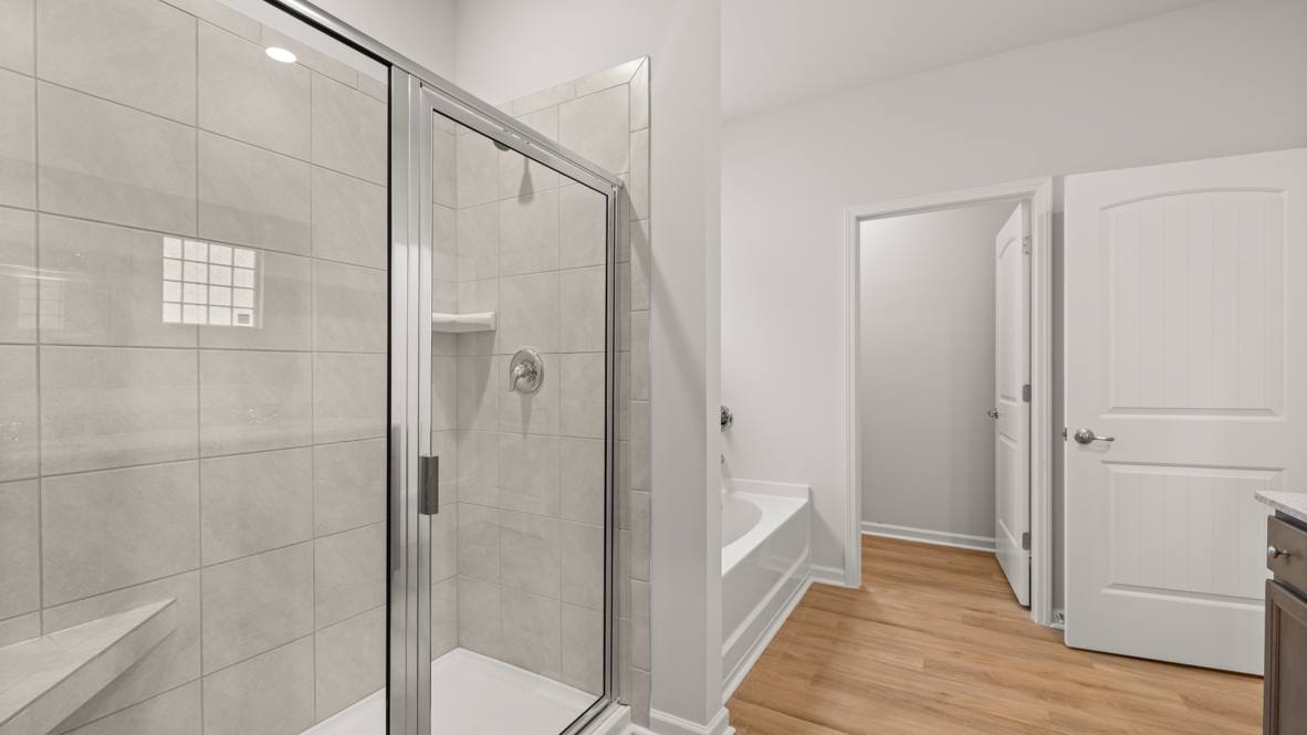 Interior primary bathroom with shower and bath tub