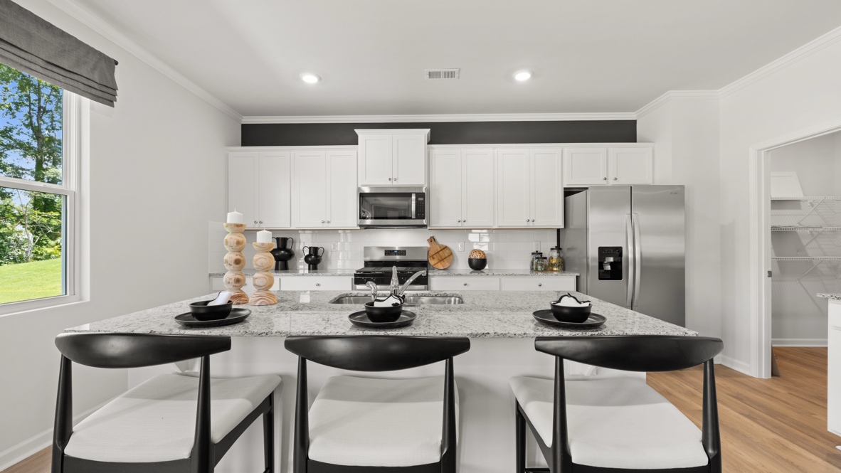 Interior kitchen with center island and white cabinets