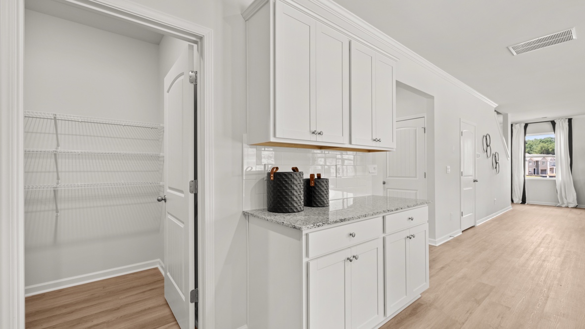 Interior kitchen with pantry and white cabinets