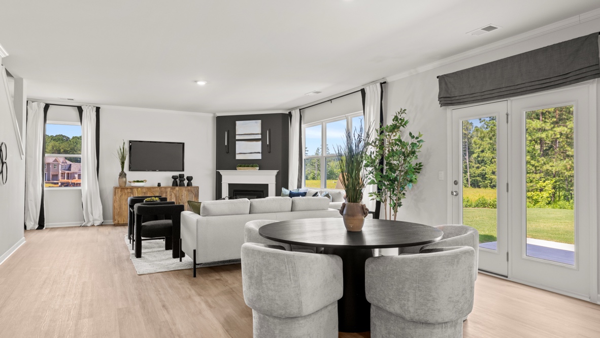 Interior dining area next to living area with large windows