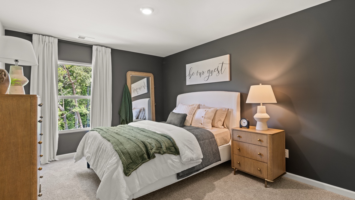 Interior bedroom with large window and dark grey accent wall