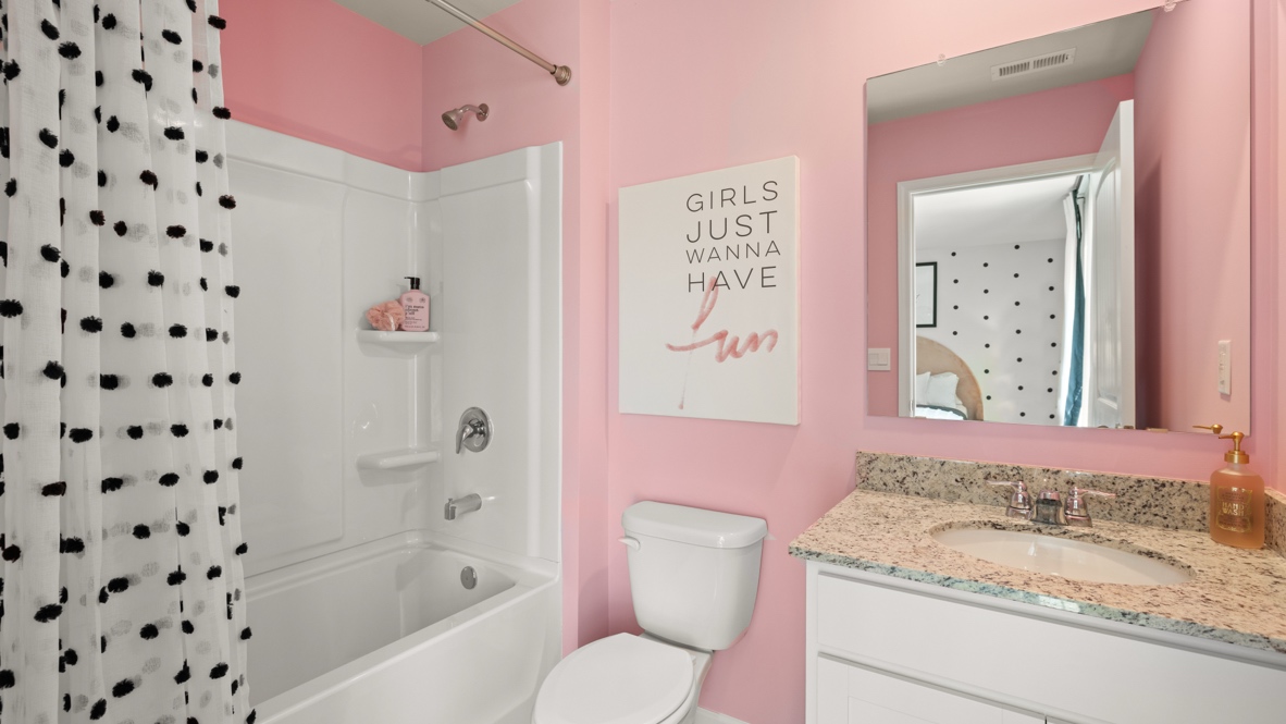 Interior bathroom with pink accent wall and full-sized shower
