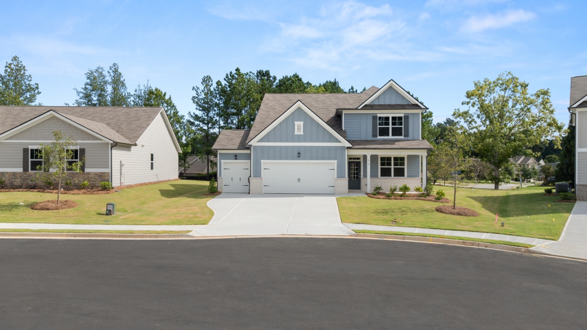 Exterior two-story home with light blue cladding and stone detailing