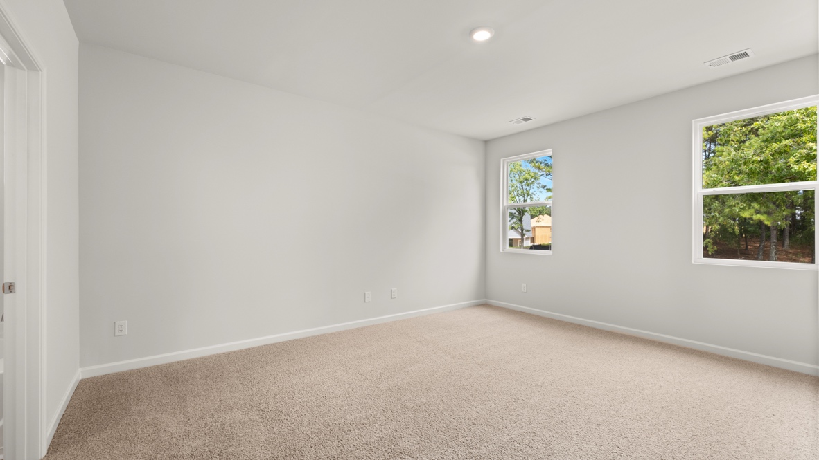 Interior primary bedroom with large windows