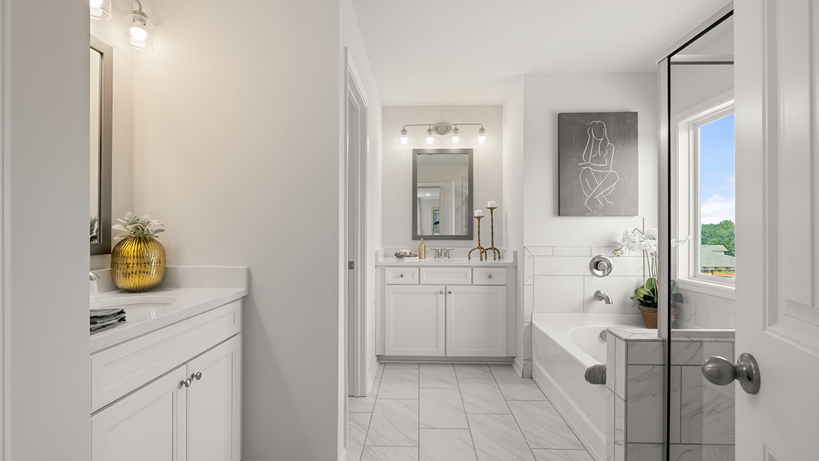 Interior primary bathroom with two sinks and bath tub