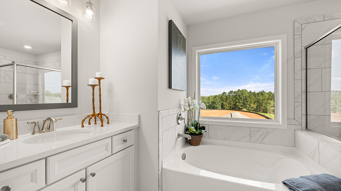 Interior primary bathroom with two sinks and bath tub