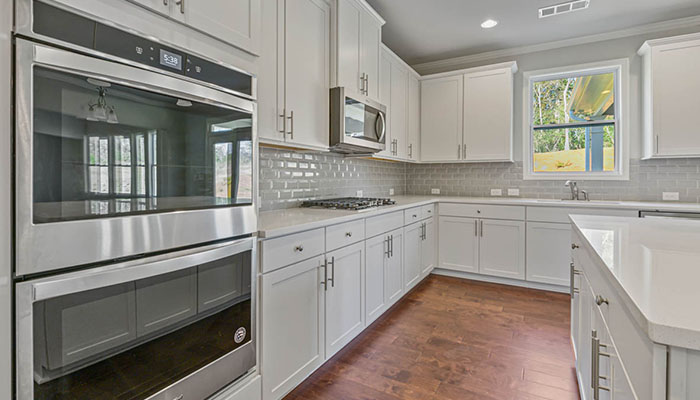 Interior kitchen with center island and white cabinets