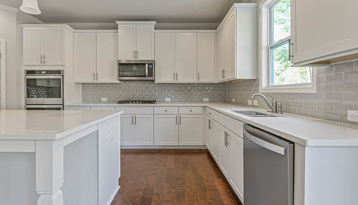 Interior kitchen with center island and white cabinets