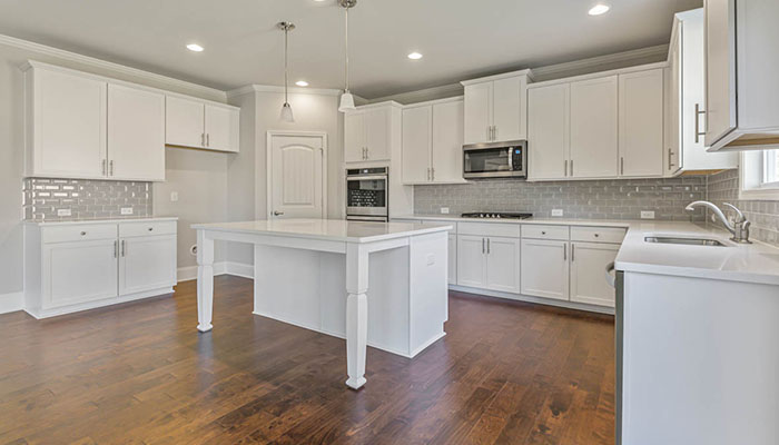 Interior kitchen with center island and white cabinets