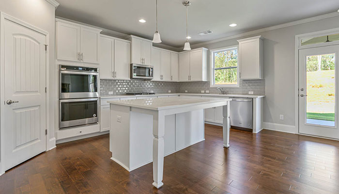 Interior kitchen with center island and white cabinets