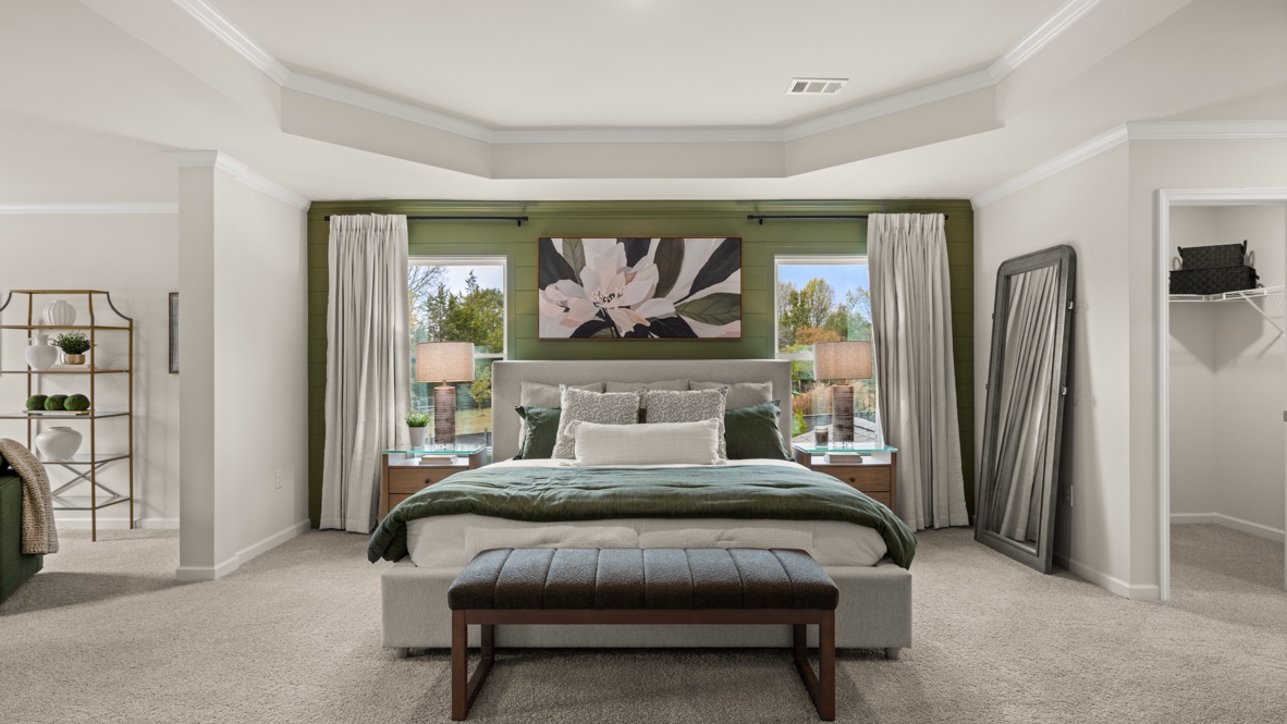 Interior primary bedroom with large windows and accent wall