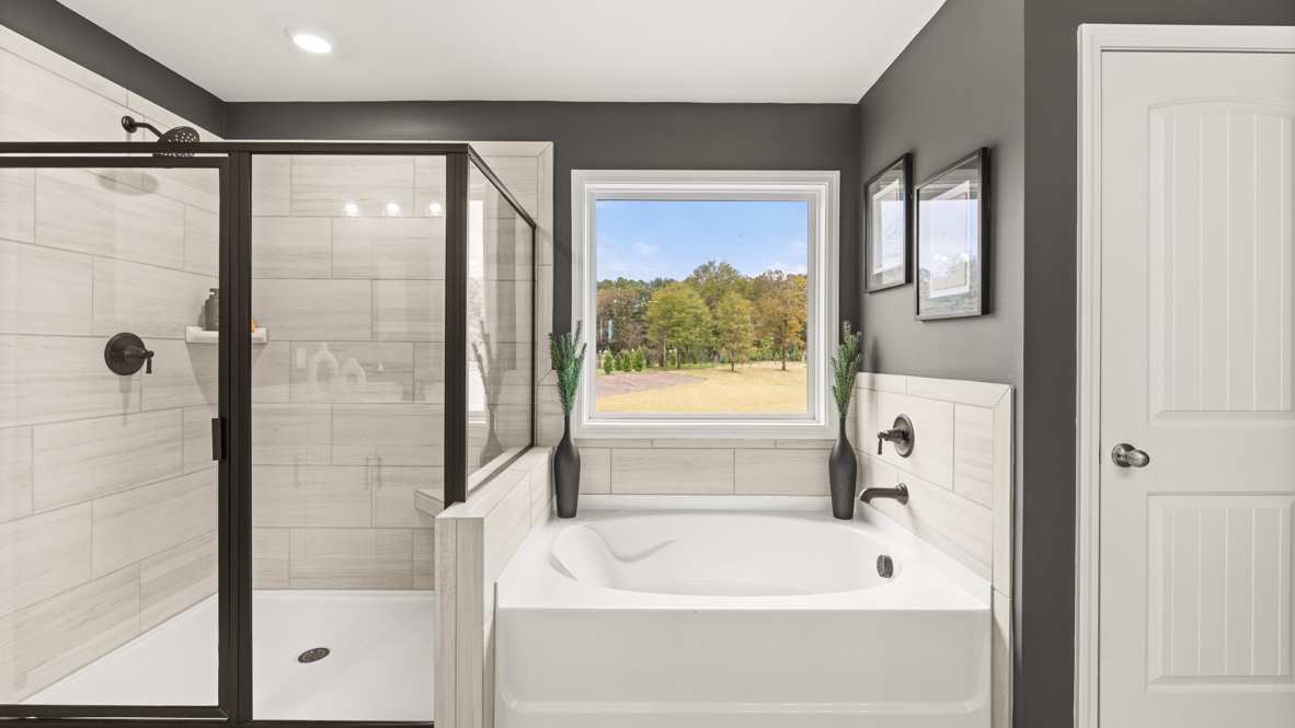 Interior primary bathroom with shower and bath tub