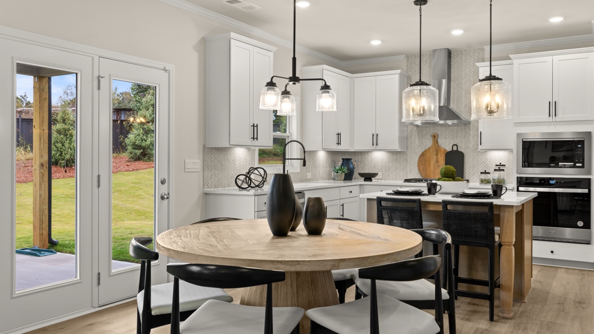 Interior dining area open to kitchen with center island and white cabinetsw