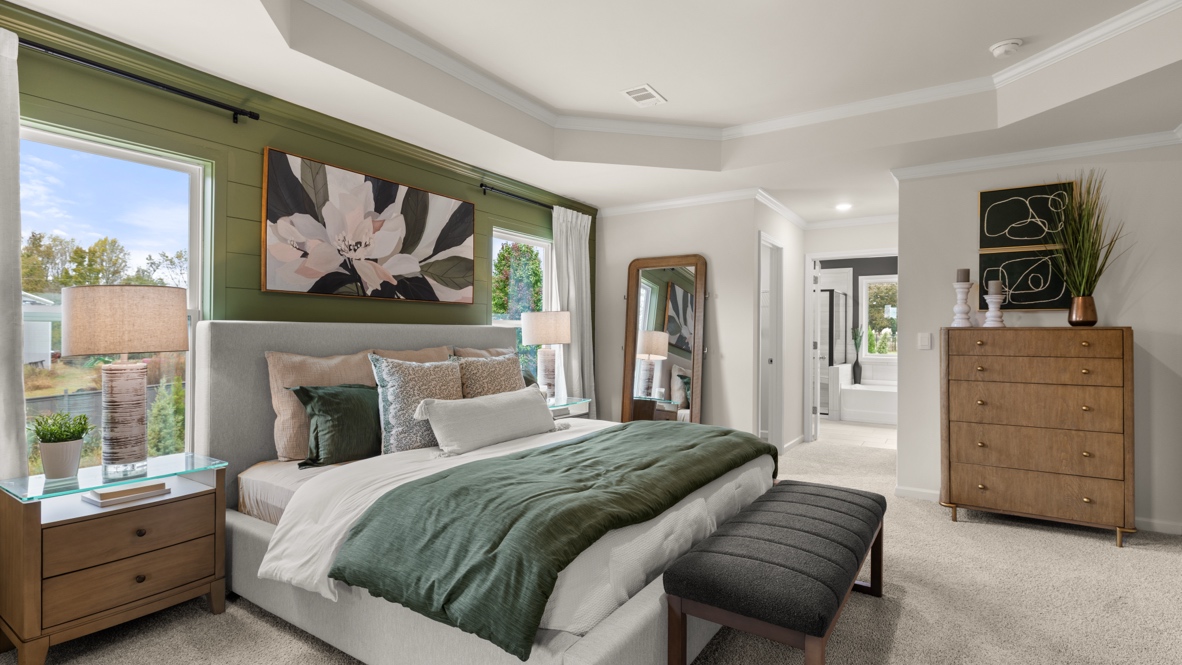 Interior primary bedroom with accent wall and windows