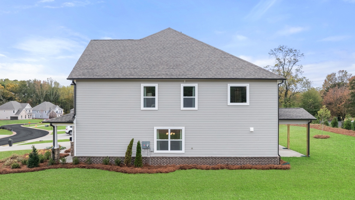 Exterior rear view of home with back yard