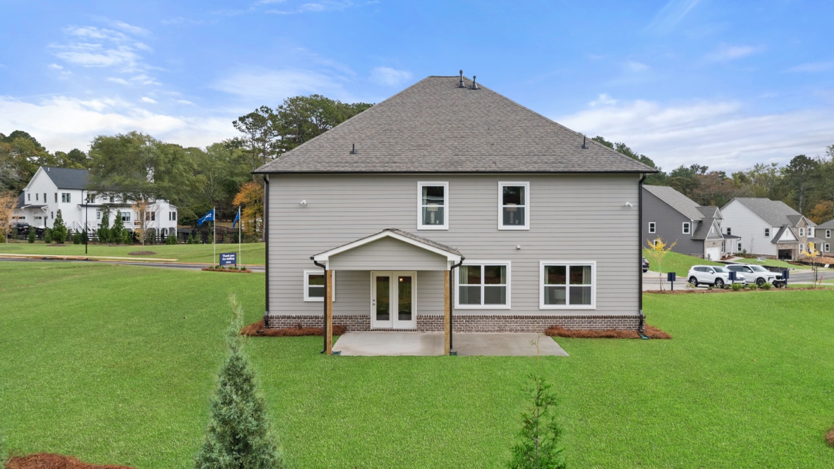 Exterior rear view of home with back yard
