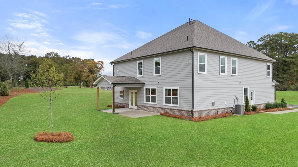 Exterior rear view of home with back yard