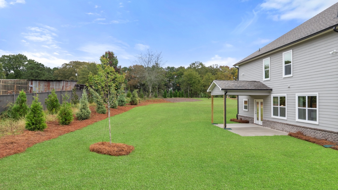 Exterior rear view of home with back yard